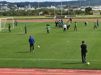 コート上で休憩をとっているサッカー選手たちの写真