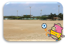とてもよく晴れた空の下日差しがまぶしい運動広場の写真