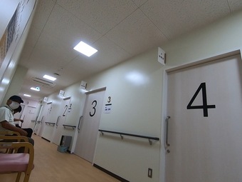 4つの診察室の前の椅子に患者が座っている読谷村診療所の写真