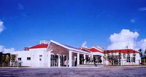 赤い屋根に白い壁の、1階建ての福祉施設全体の写真