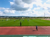 青空の下で練習試合を行っているサッカー選手たちの写真