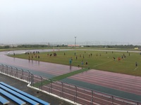 雨の中行われているラグビーの試合の様子を遠くから撮影した写真