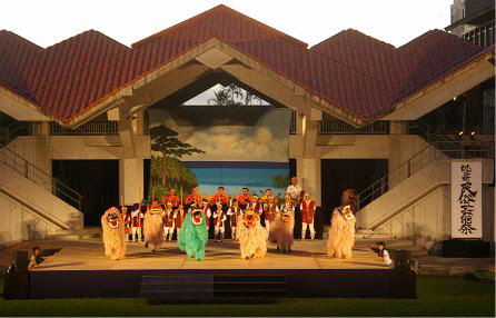 舞台上で色とりどりの衣装を着た人たちが並んでいる鳳ホールで行われた読谷村民俗芸能祭の様子の写真
