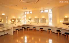 壁に沿って化粧用の鏡とテーブルと椅子が多数設置されている鳳ホールの楽屋・洋室の写真