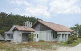 赤茶色の三角屋根をした平屋の読谷村陶芸研修所の外観写真