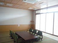 座敷にテーブルと6台の座椅子が設置された和室の待合室の写真