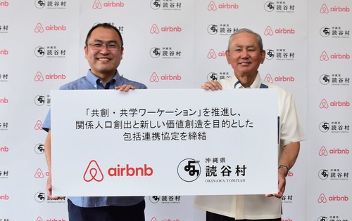 Airbnb Japan株式会社と村長が一緒に包括連携協定を持って正面に向けている写真